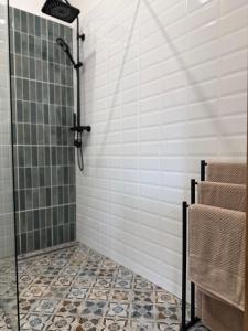 a shower stall in a bathroom with a tile floor at Szumi Las Bed & Breakfast in Józefów