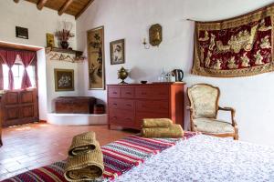 a bedroom with a bed and a chair and a dresser at Montes de Baixo in Odeceixe
