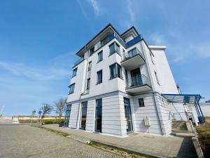 a white building sitting on the side of a street at Marthes Seeblick in Warnemünde +11 photos