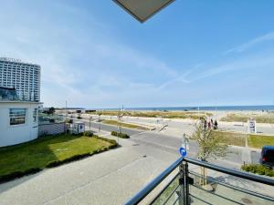 a balcony with a view of the beach and a building at Marthes Seeblick in Warnemünde