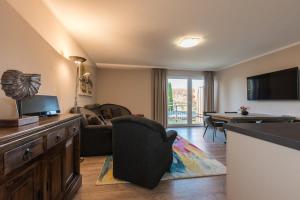 a living room with a television and a couch and a table at Haus Leuchtfeuer/Eagle in Warnemünde