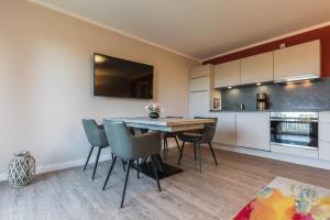 a kitchen and dining room with a table and chairs at Haus Leuchtfeuer/Eagle in Warnemünde