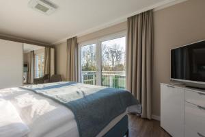 a hotel room with a bed and a large window at Haus Leuchtfeuer/Eagle in Warnemünde