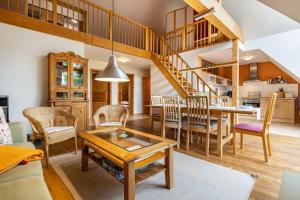 a living room with a table and chairs and a staircase at Alte Scheune in Putbus