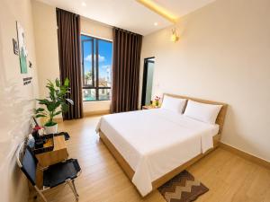 a bedroom with a white bed and a large window at Pi Home in Dong Hoi +58 photos