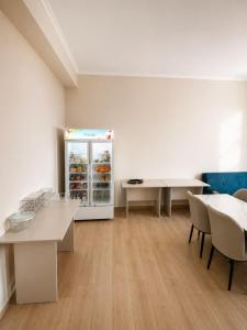 a room with a refrigerator and tables and chairs at Datka Hotel in Bishkek