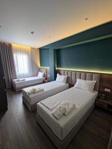 a hotel room with two beds and a couch at HOTEL CENTERPOINT Tirana in Tirana
