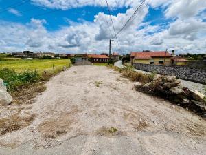 an empty dirt road in a field with houses at La Casita cerca de la playa in Santander