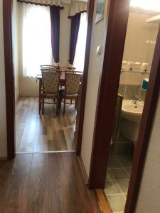 a bathroom with a table and chairs and a sink at Thermal Apartman 01 in Kiskőrös