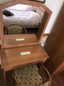 a bedroom with a bed and a wooden desk with a drawer at Thermal Apartman 01 in Kiskőrös +4 photos