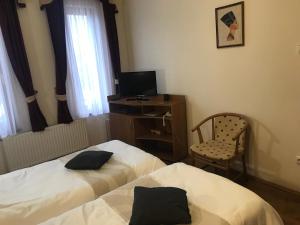 a hotel room with two beds and a desk and a chair at Thermal Apartman 01 in Kiskőrös