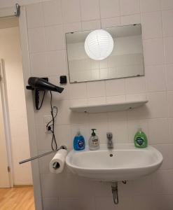 a bathroom sink with a hair dryer and a mirror at Exklusives Dach-Loft Helles Wohnerlebnis in Elmshorn