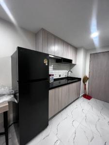 a kitchen with a black refrigerator in a room at Bristol Court in Kathmandu