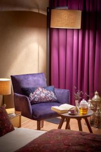 a living room with a purple couch and a table at Ayurveda Resort MANDIRA in Bad Waltersdorf