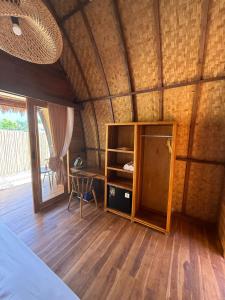 a room with a bed and a desk in a room at Kokonut Resor Amed in Amed