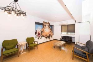 a living room with a painting of a cat on the wall at Traveller Inn - Mido Hotel in Taitung City