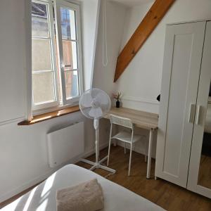 a bedroom with a desk with a fan and a window at Calme et confort au cœur du vieux Troyes in Troyes +74 photos