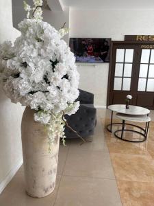 a vase filled with white flowers in a room at Hotel Parc in Craiova