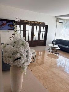 a vase filled with white flowers in a lobby at Hotel Parc in Craiova +31 photos