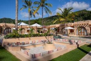 a resort with a pool and palm trees at Miliyana Boutique Hotel - Adults Only in Kuta Lombok