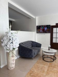 a living room with a blue couch and a table at Hotel Parc in Craiova