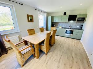 a kitchen and dining room with a wooden table and chairs at Ferienhaus Viewpoint in Warnemünde
