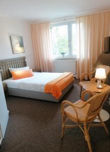 a bedroom with a bed and a chair and a window at Landhaus Martens in Bresewitz