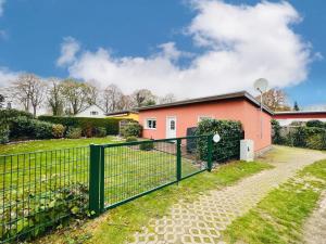 a fence in front of a pink house at Ferienhaus Streuwiese in Warnemünde