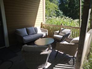 a porch with a couch and chairs and a table at Ruissalo Cottage in Turku
