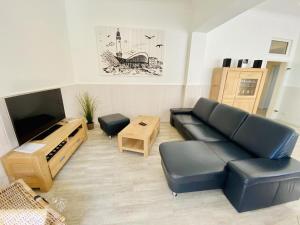 a living room with a couch and a tv at Berringer, Knurrhahn, direkt an der Promenade in Warnemünde
