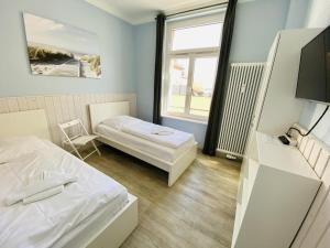 a small room with two beds and a television at Berringer, Knurrhahn, direkt an der Promenade in Warnemünde