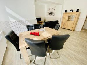 a dining room table with black chairs around it at Berringer, Knurrhahn, direkt an der Promenade in Warnemünde
