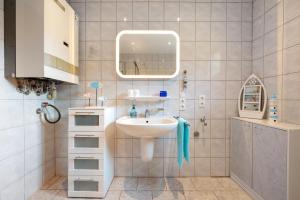 a bathroom with a sink and a mirror at Ferienwohnung Bahlmann in Garrel +21 photos