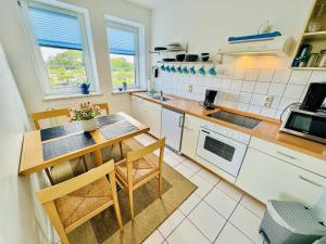 a kitchen with a table and chairs in it at Landhaus Immenbarg, Dünenblick in Warnemünde