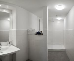 a white bathroom with a shower and a sink at Landhaus Immenbarg, Dünenblick in Warnemünde +16 photos