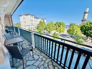 a balcony with chairs and a view of a lighthouse at Berringer, Barsch, direkt an der Promenade in Warnemünde