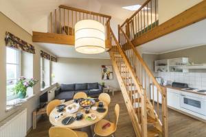 a kitchen and a living room with a table and a staircase at Landhaus Immenbarg, Alter Strom in Warnemünde