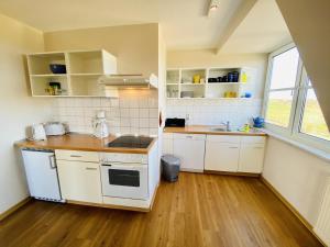 a small kitchen with white cabinets and a sink at Landhaus Immenbarg, Alter Strom in Warnemünde +13 photos
