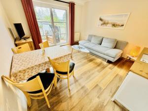 a living room with a table and a couch at Landhaus Immenbarg, Auszeit in Warnemünde
