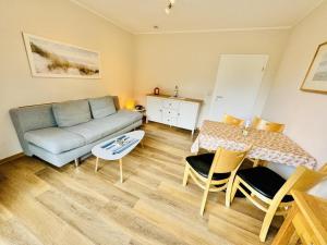 a living room with a couch and a table at Landhaus Immenbarg, Auszeit in Warnemünde