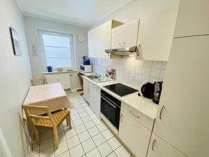 a small kitchen with a table and a refrigerator at Landhaus Immenbarg, Auszeit in Warnemünde +14 photos