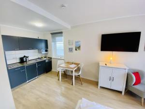 a small kitchen with a table and a couch at Landhaus Immenbarg, Lobby in Warnemünde +7 photos