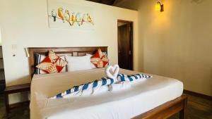 a bedroom with a bed with white and blue pillows at Blue Beach Villa - Nilwella in Matara +43 photos