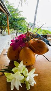 a bunch of fruit sitting on a table with flowers at Blue Beach Villa - Nilwella in Matara