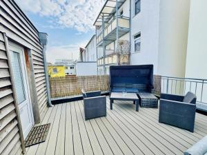 a balcony with a couch and a table on a building at Haus Juliane, Lichtblick in Warnemünde