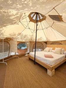 a bed on a boat with an umbrella at Pink lemon Galmping in Elche