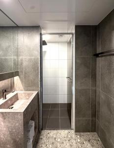 ein Badezimmer mit Dusche und Waschbecken in der Unterkunft Urban Brown Hotel in Gunsan + 88 Fotos