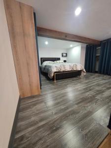 a bedroom with a bed and a wooden floor at Le calme in La Souterraine