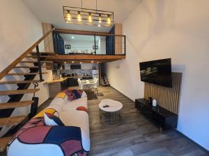 a living room with a couch and a staircase at Le calme in La Souterraine