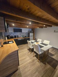 a dining room with a table and white chairs at Le calme in La Souterraine +7 photos